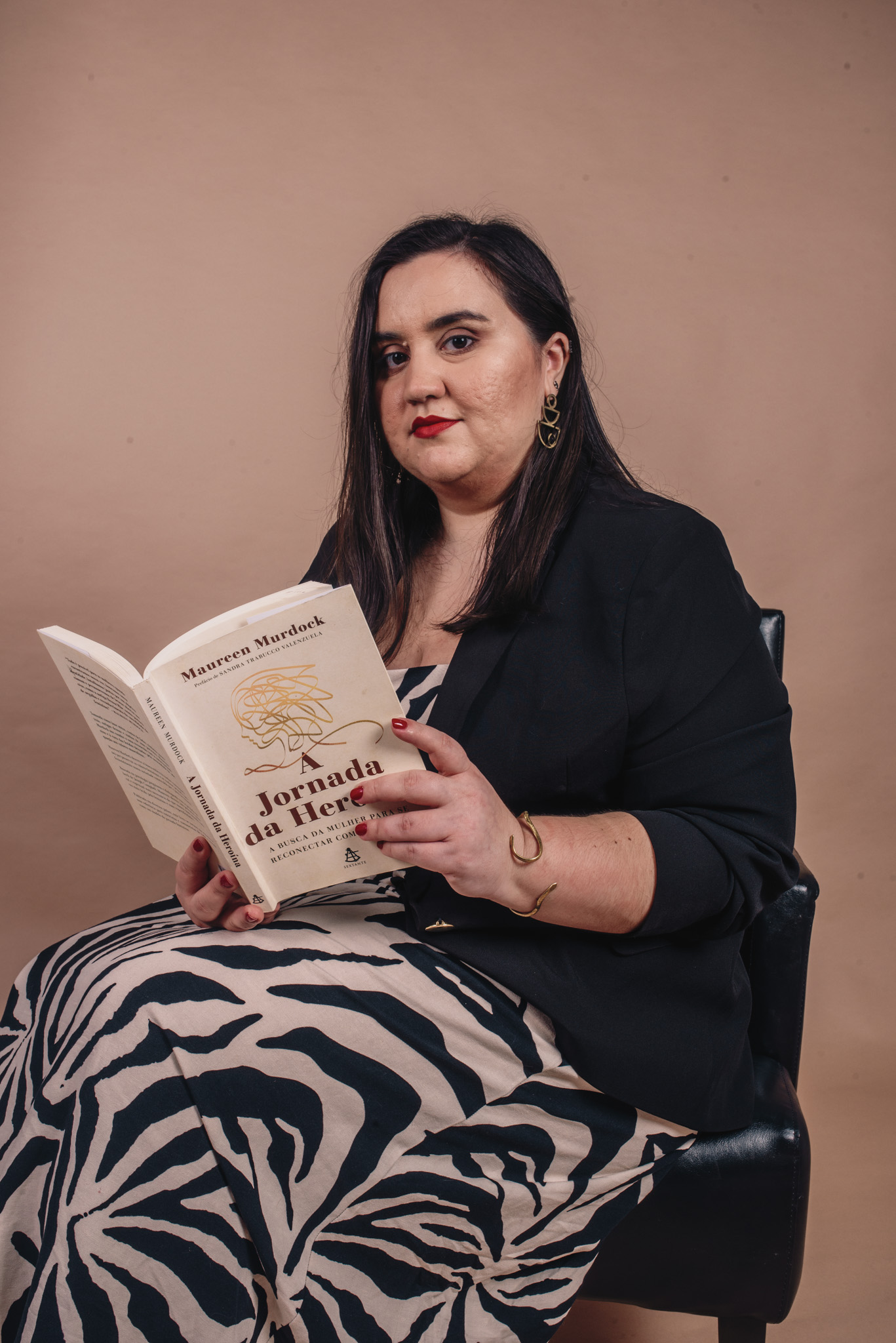 Luana Carvalho sentada com um livro nas mãos